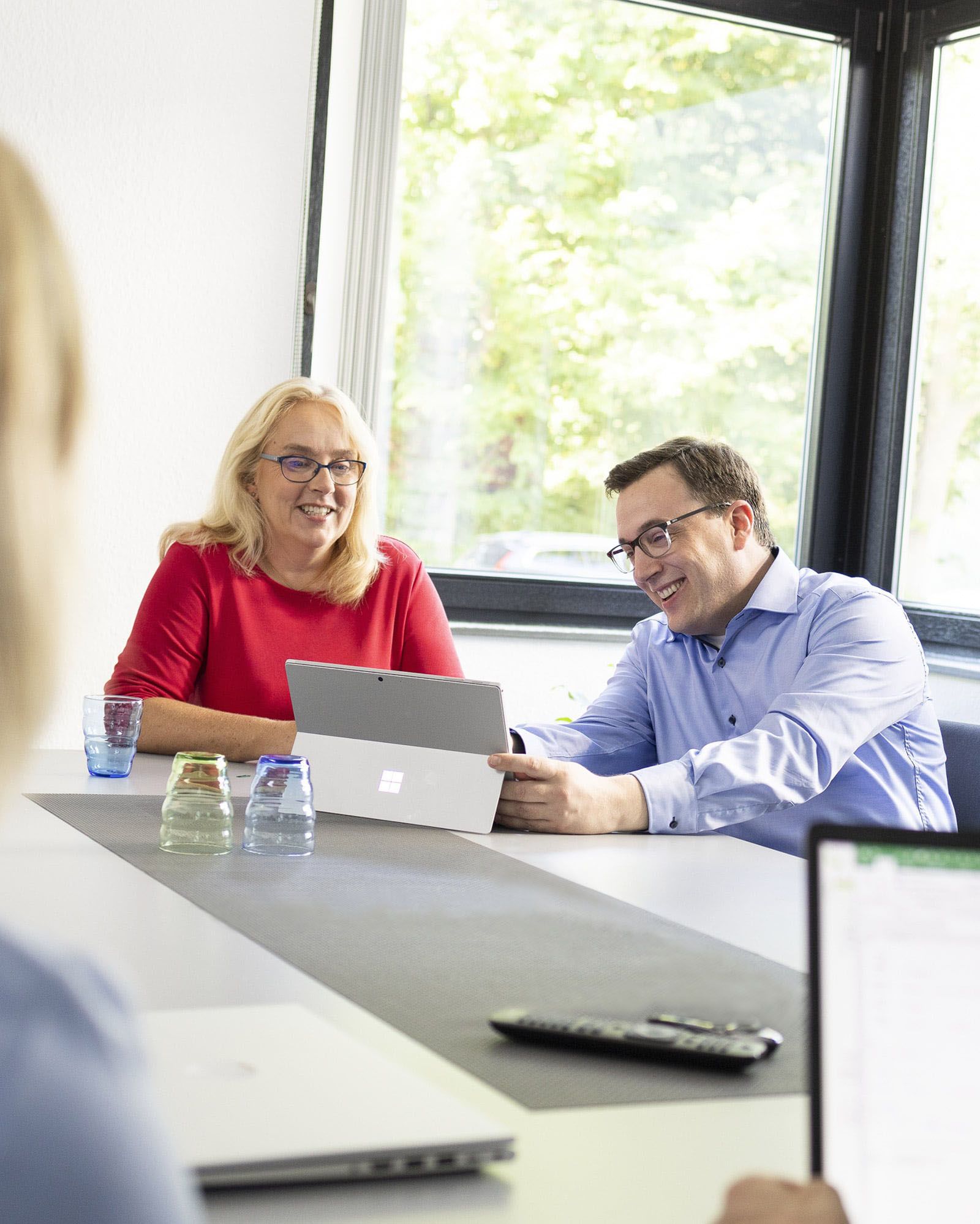 Frau Vox und Herr Beusker sitzen am Tisch in einer Besprechung