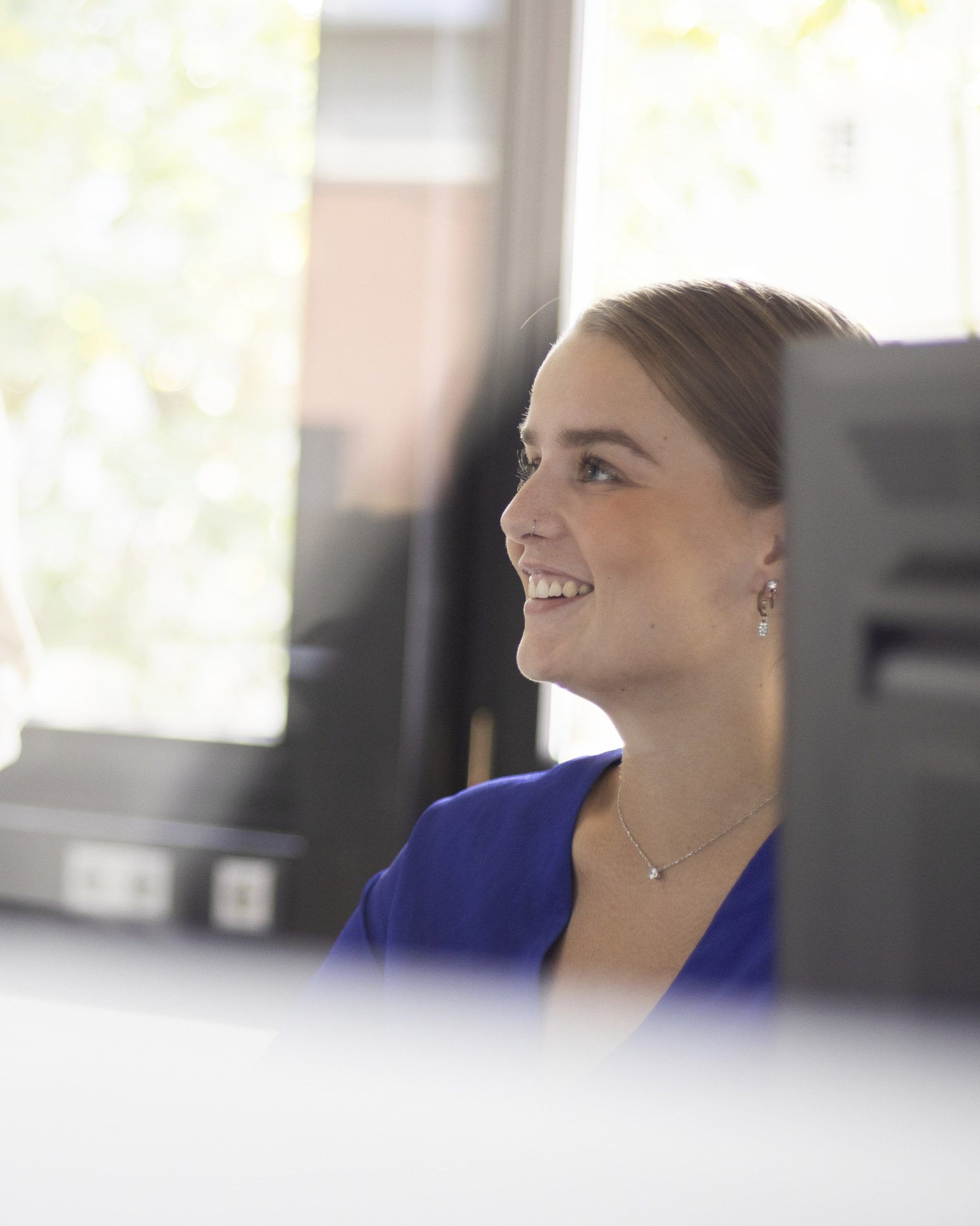 Eine Mitarbeiterin sitzt am Schreibtisch