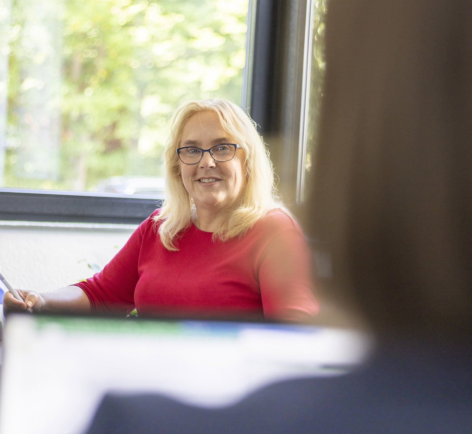 Frau Vox im Dialog mit einer Mitarbeiterin am Schreibtisch