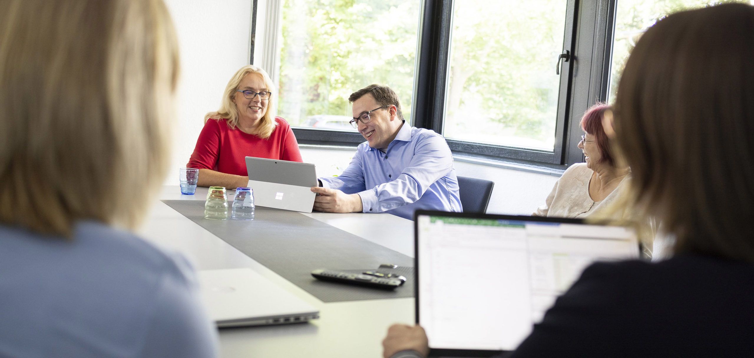 Das Team sitzt zusammen in einer Besprechung an einem großen Tisch